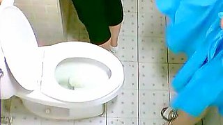 Two cute Asian girls spotted on a toilet cam pissing