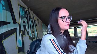 Glasses girl strokes that dick and takes it under the bridge