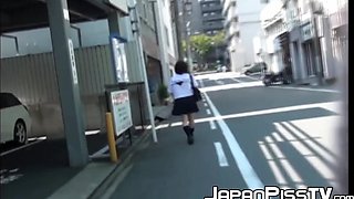 Ginger-haired Asian with brief hair is pissing on the streets